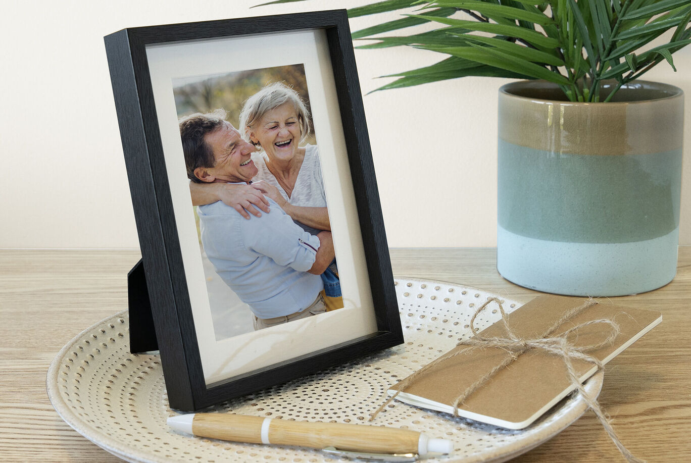 Una foto enmarcada amorosamente sobre una mesa, rodeada de un cuaderno y un bolígrafo.