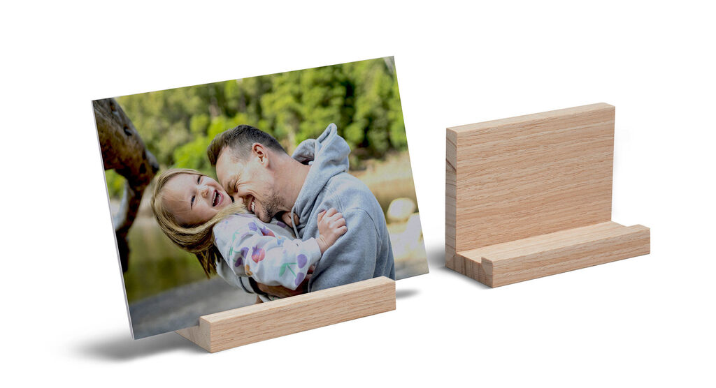 Soporte de madera para revelados de fotos. Aparece una foto en el soporte de un padre con su hija en un revelado de papel 100% reciclado.