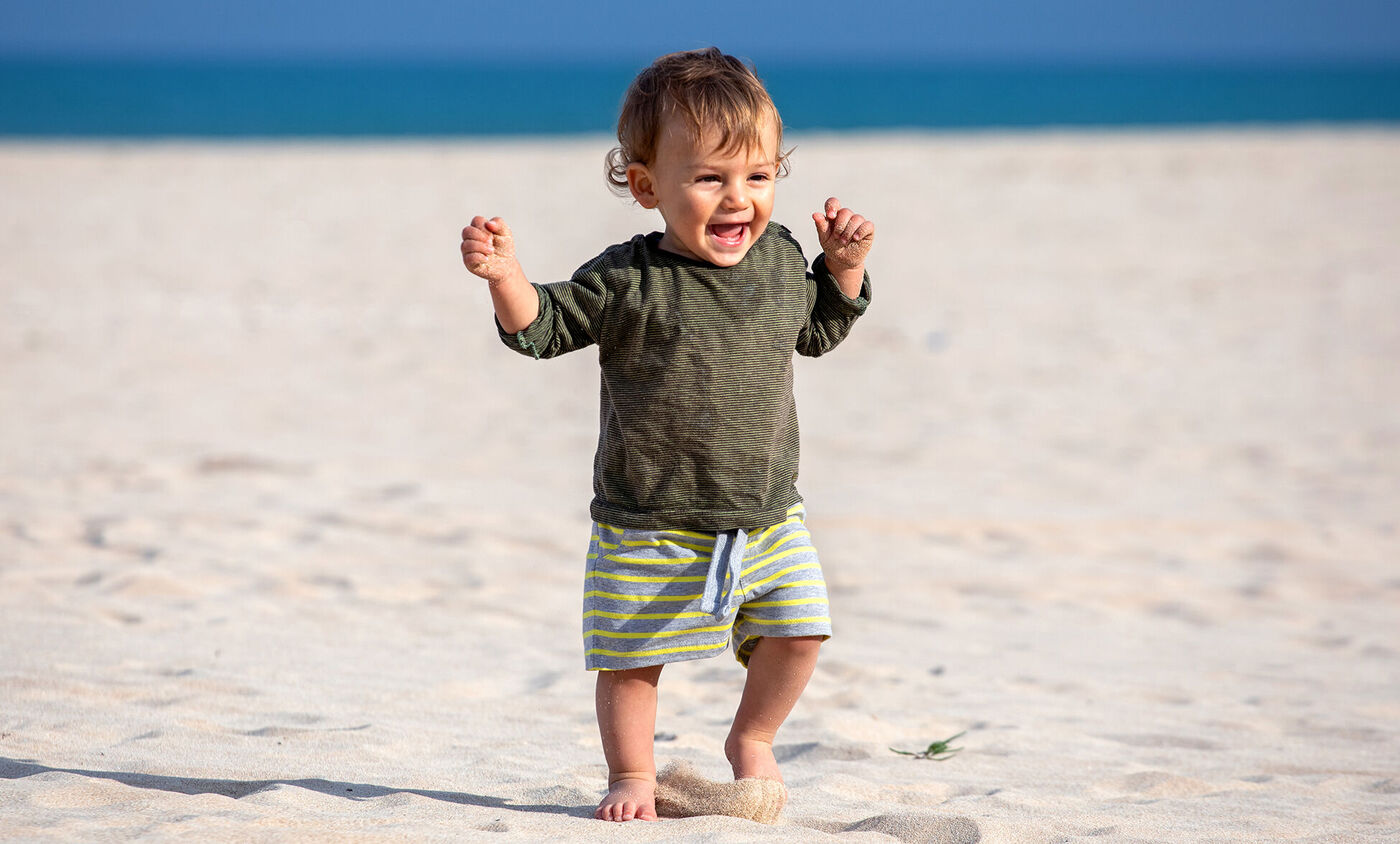 niño pequeño disfrutando de la playa.