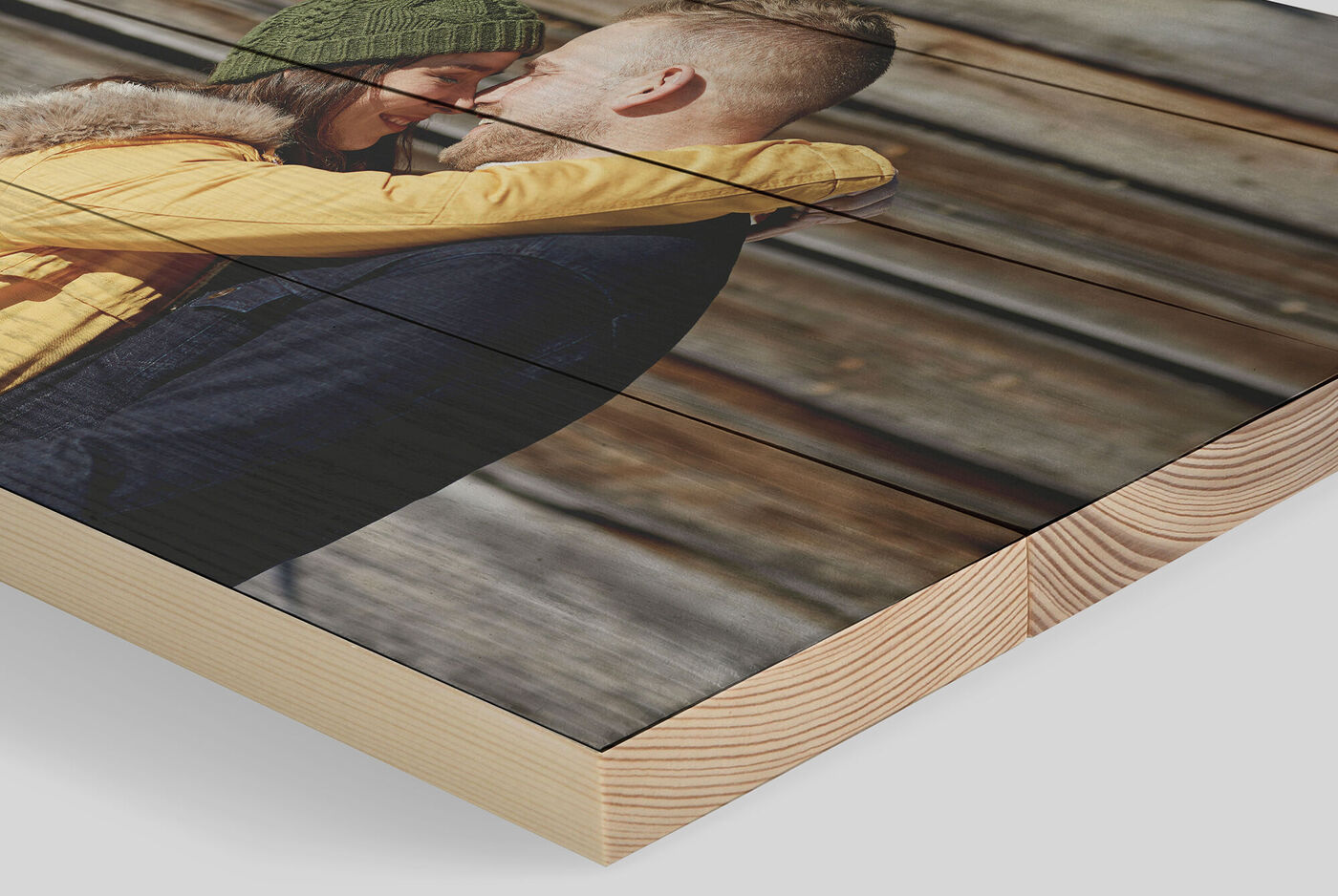 Pareja se abraza frente a un fondo de madera