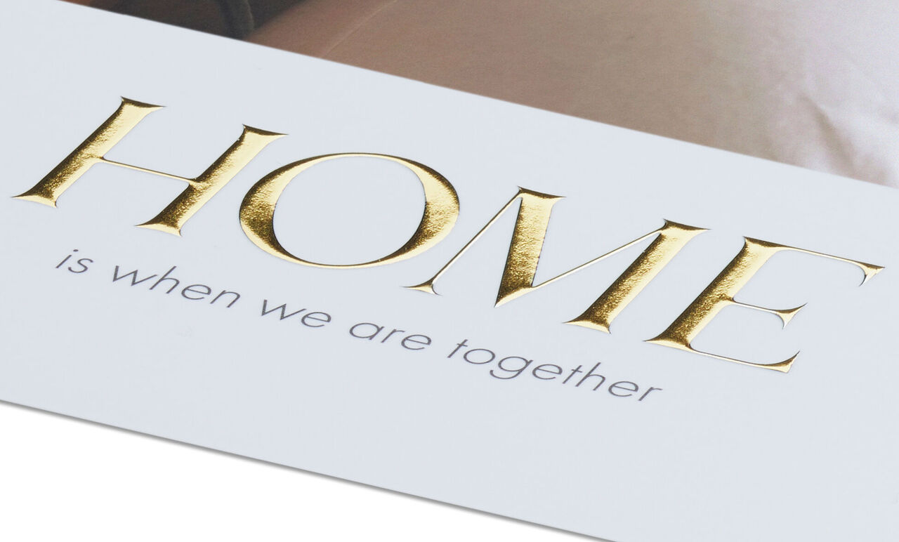 Imagen de pared con la inscripción 'HOME es cuando estamos juntos' en oro y gris.