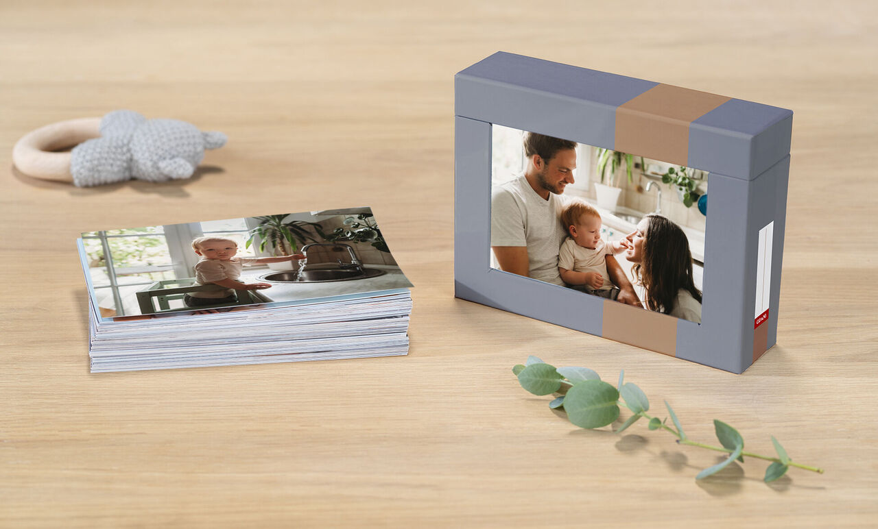 Maravilloso álbum de fotos CEWE sobre una mesa con fotos.