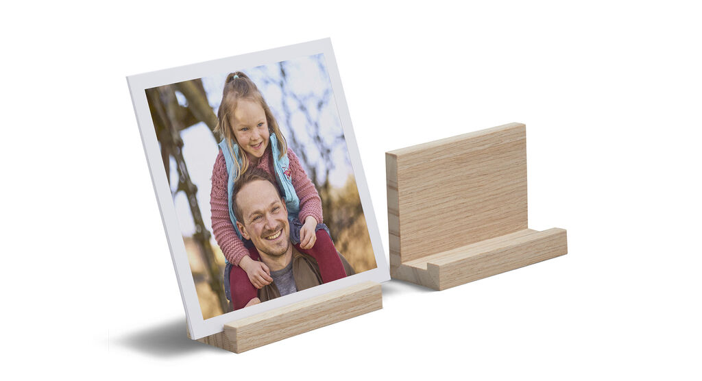 Una foto enmarcada de un niño feliz sobre un soporte de madera.