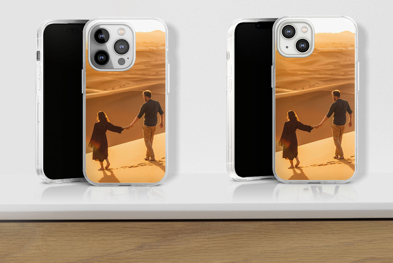 Dos smartphones con fundas personalizadas sobre una mesa, fotos de una pareja en el desierto.