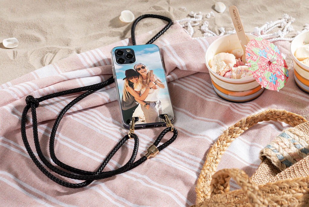 Teléfono con foto personalizada en una toalla de playa junto a dos helados.