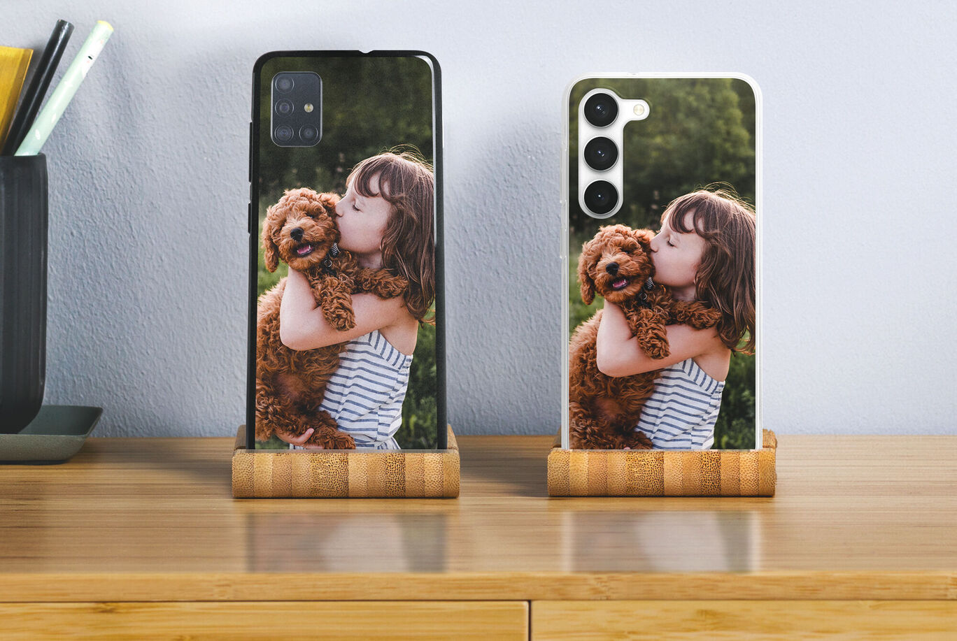 Dos teléfonos con fundas personalizadas mostrando una niña abrazando cariñosamente a un perro.