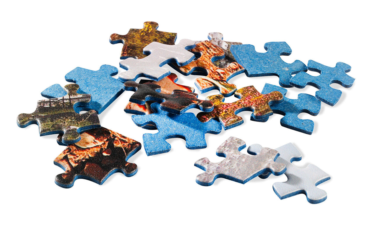Piezas de puzzle coloridas esparcidas sobre un fondo blanco