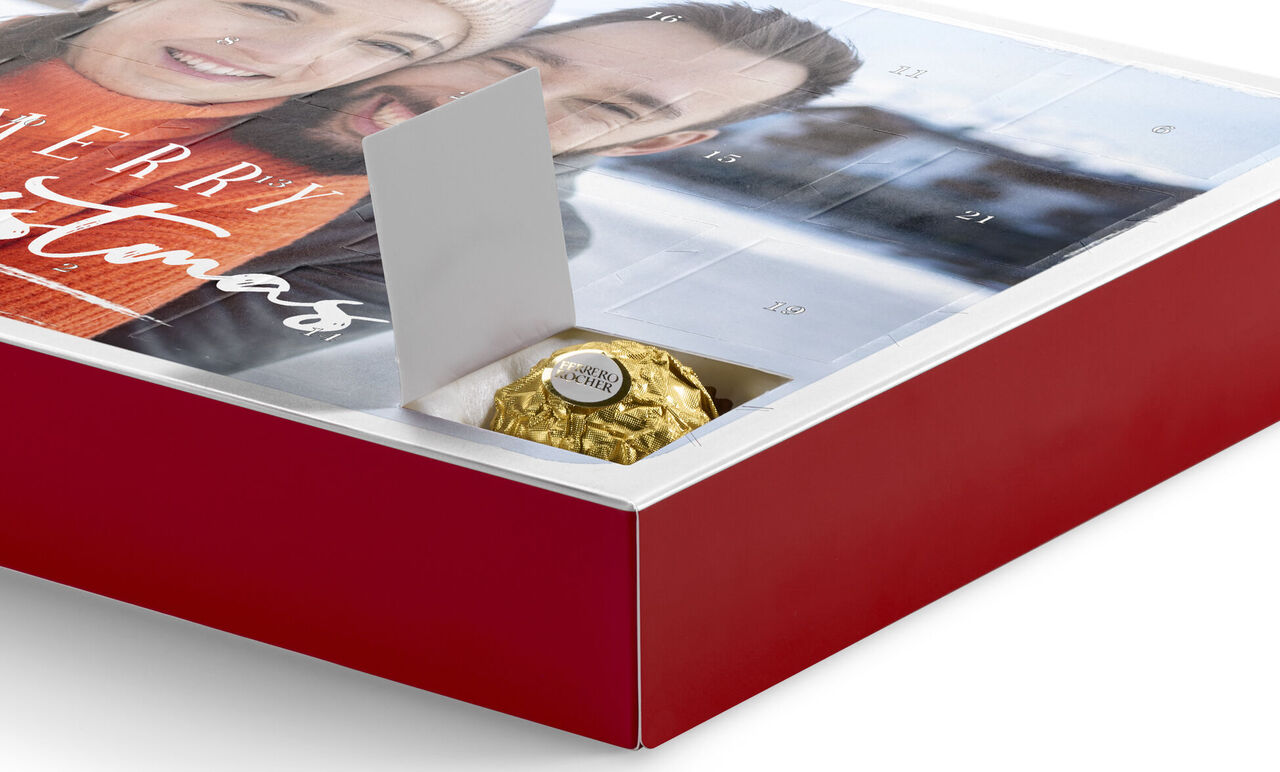 Un hermoso calendario de adviento con un empaque festivo que contiene un bombón dorado.