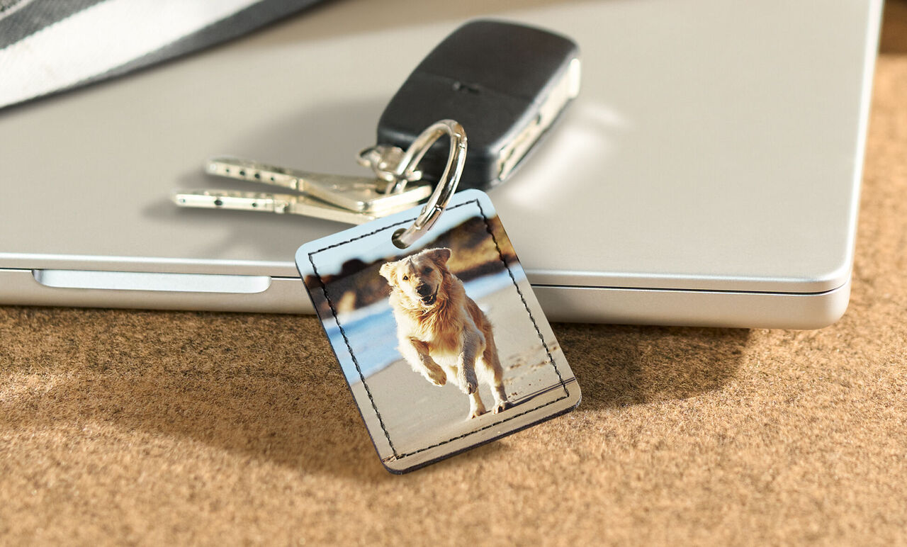 Un llavero con una foto de un perro corriendo en la playa