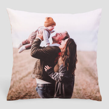 Una pareja feliz levanta a un niño mientras están en la naturaleza compartiendo alegría