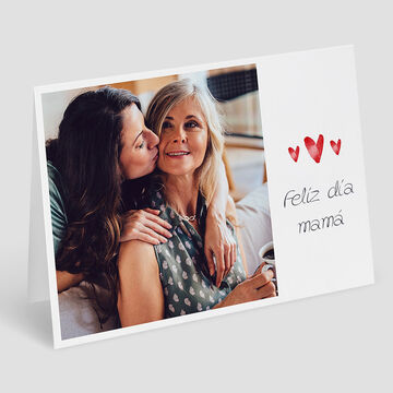 Dos mujeres se abrazan felices en una mesa.